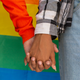 women holding hands with rainbow flag